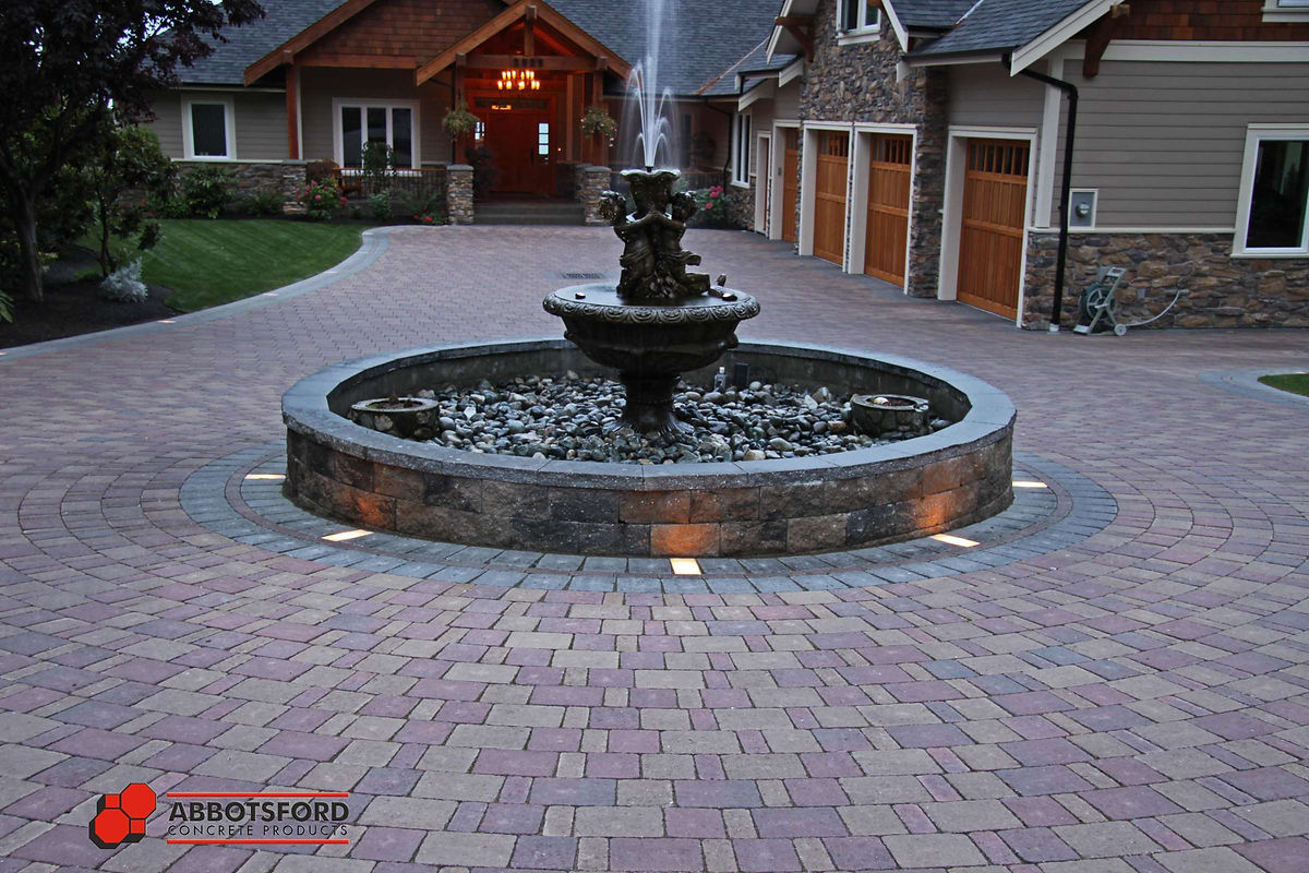 Paving stone accent lighting at night by Deerwood Landscaping
